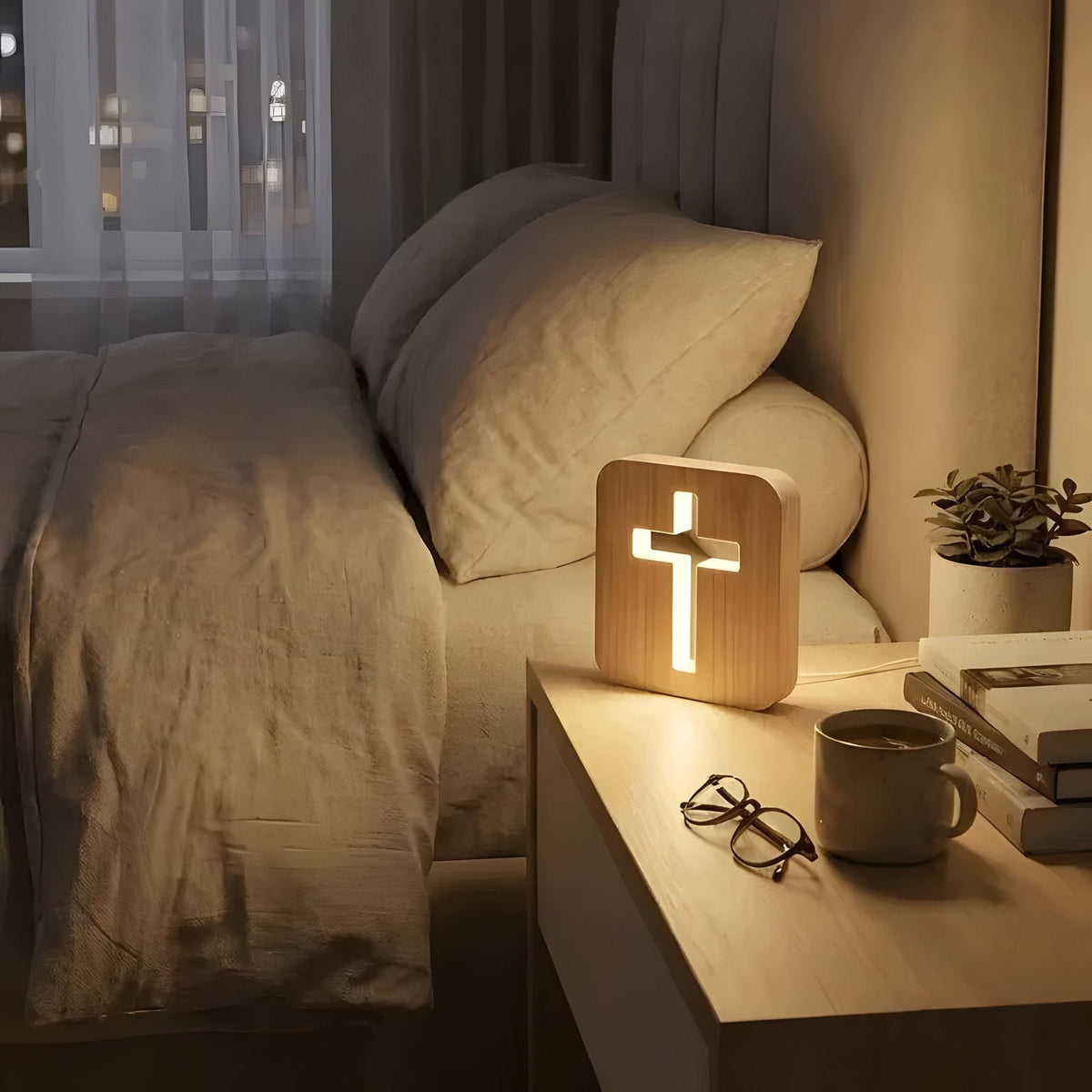 Wooden cross lamp on bedside table next to a soft pillow